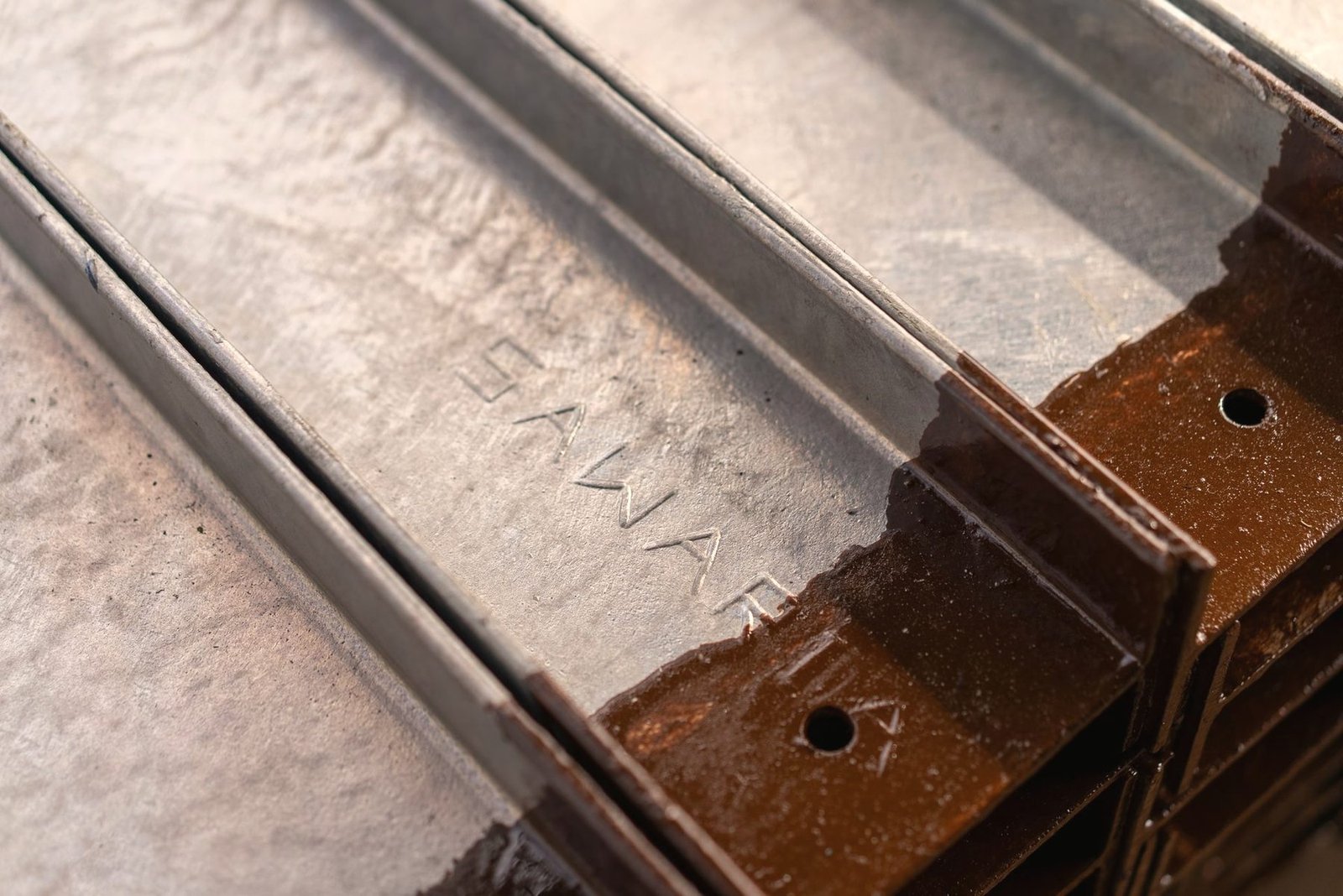 Close view of a rusted steel channel section before preparation.